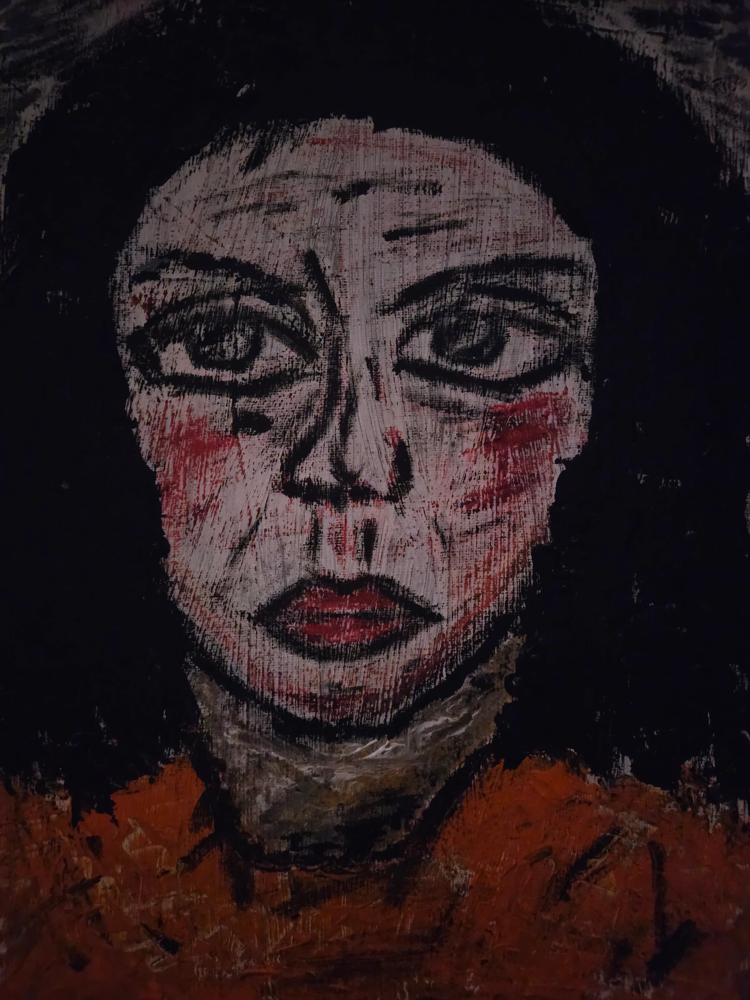 Frontal painted face in pale pink, black and red against a dark background, with lowered eyes and red cheeks.