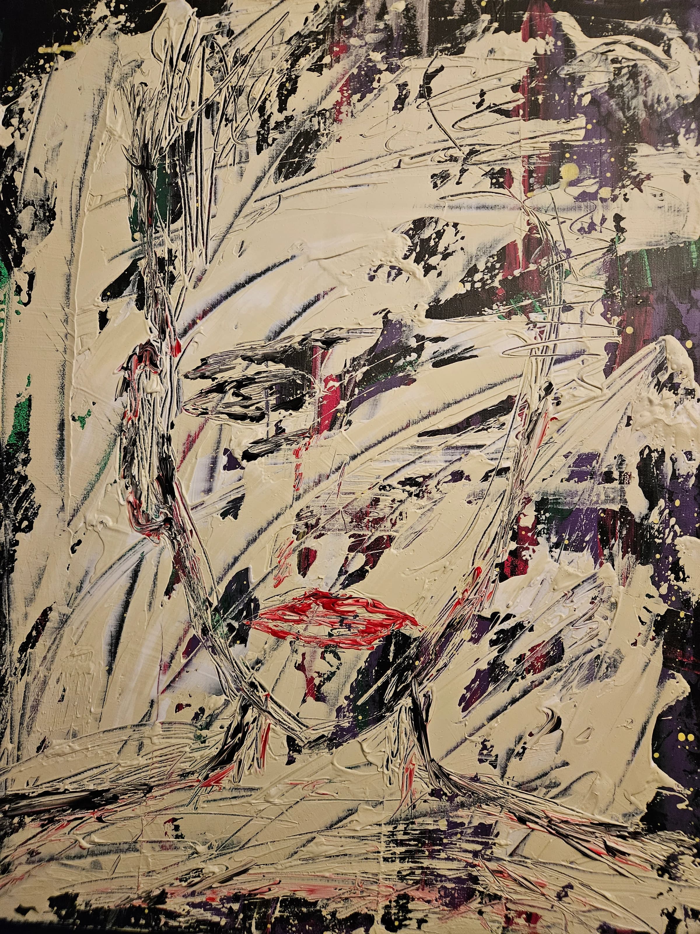 Painted face in thick off-white paint with black, purple, green and red marks, including bright red lips.